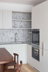 Kuchyně ve tvaru L, navržená s důrazem na logický provoz. (Interiér bytu Karlín; PANIKHORN)