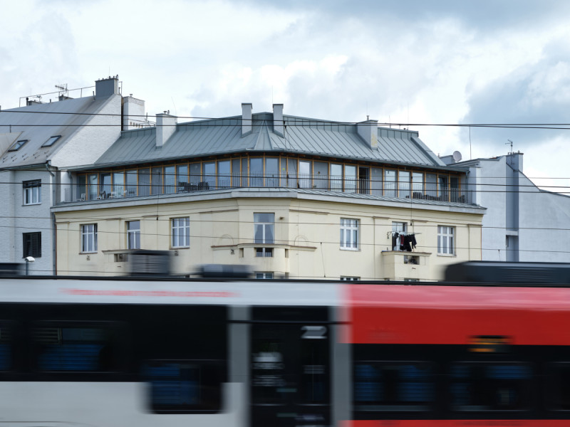 Seříznutím roviny střechy za korunní římsou vznikla nová ustoupená fasáda s francouzskými okny a průběžnou terasou. (Nástavba Harfa; matěj šebek architekti)