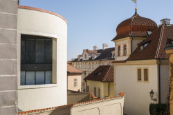 Zaoblení stavby reaguje na nepravidelnou stopu původní obvodové zdi i tvar slepé uličky Tržiště. (Bytový dům na Malé Straně; architektonický ateliér Ladislava Lábuse)