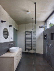 Jednoduchý koupelnový interiér – beton a šedé obklady (Vila Troja, Stempel & Tesar architekti)