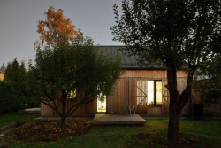 Rodinný dům na Hané, No-A Architekti: Díky modřínovému obkladu dům s okolími stromy splývá namísto toho, aby je přehlušoval výraznou barvou