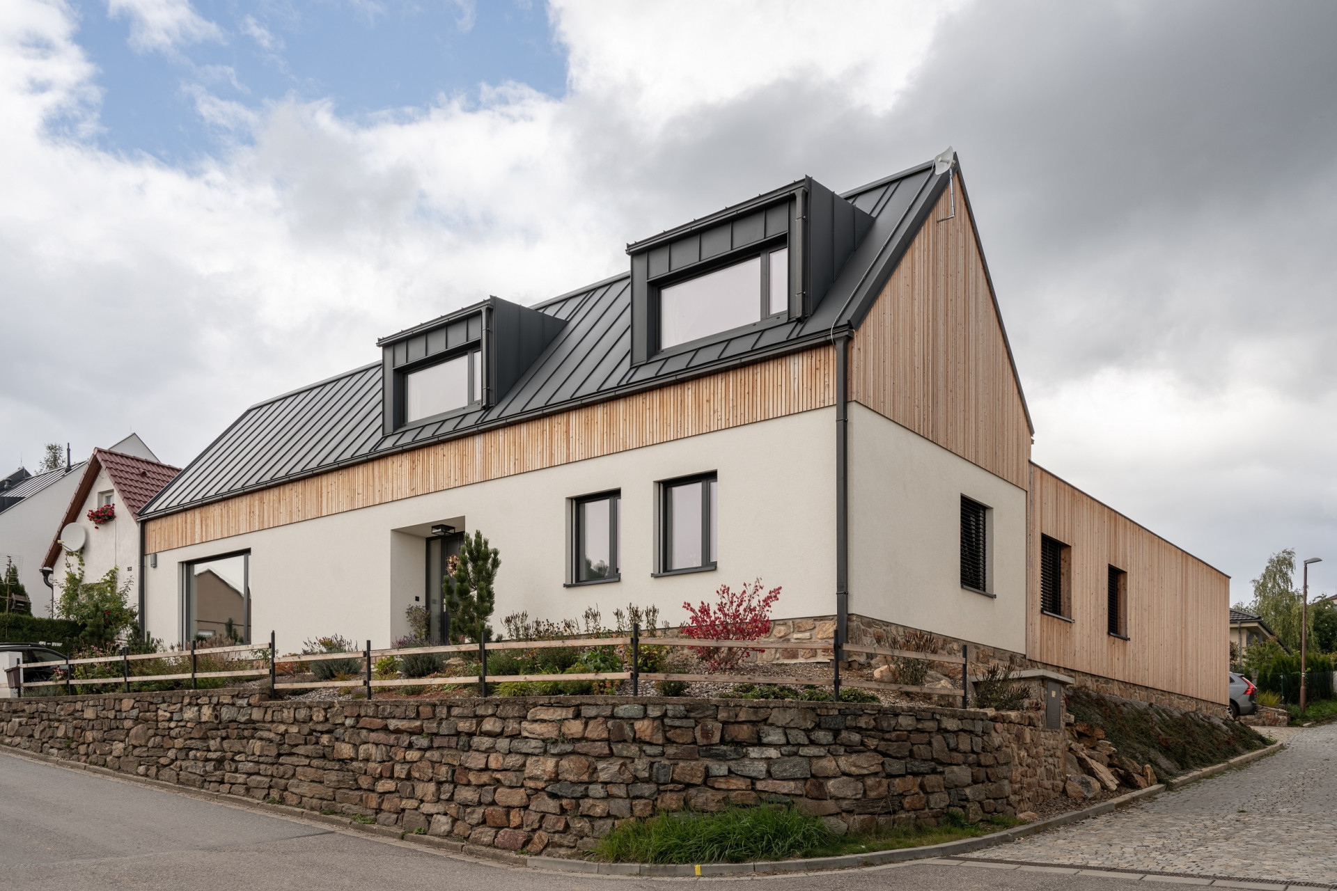 Rodinný dům v Bystřici nad Perštejnem, studio AEIOU: Rodinný dům vyrostl na místě staršího objektu. Jeho původní pozici kopíruje hlavní trakt novostavby, ze které směrem do zahrady vybíhají dvě kratší křídla