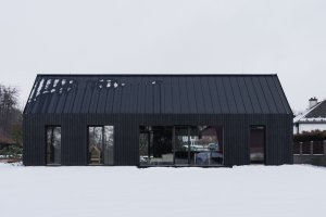 Vyjít na zahradu lze z obývacího pokoje i ložnice. (Přízemní dům s fasádou z opalovaného dřeva; Luni architekti)