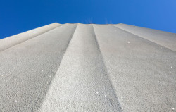 Tvarovaná cementová fasáda se třpytí na slunci. (Rose Apartments v Los Angeles, Brooks & Scarpa)