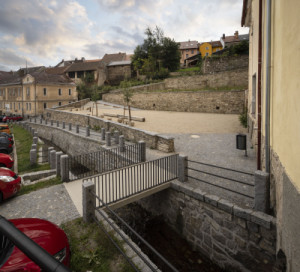 Pohled na první terasu a do odkrytého potoka s novým pěším přemostěním – bezbariérovým přístupem na terasy. (Pivovarské terasy; Steiner a Malíková krajinářští architekti, Roman Brychta Architekti)