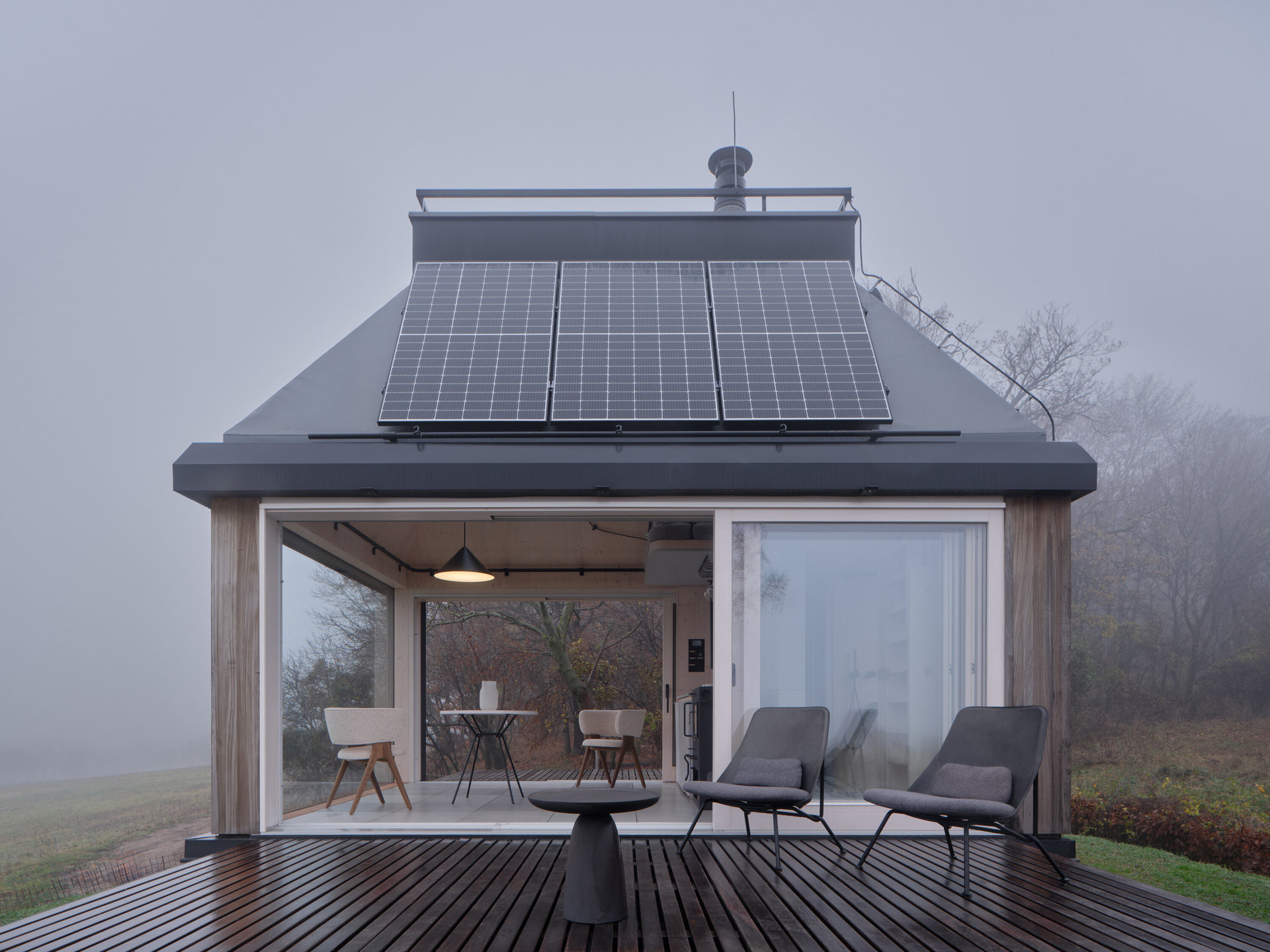 Při otevření skleněného portálu "uvnitř" a "venku" v podstatě splyne. (Domek ve vinici; Ark-Shelter, Archekta)