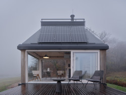 Při otevření skleněného portálu "uvnitř" a "venku" v podstatě splyne. (Domek ve vinici; Ark-Shelter, Archekta)