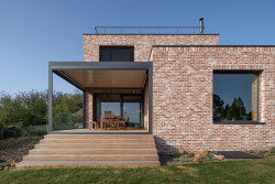 Fasáda je z režných cihel. (Dům v Olešku, AbtSmolen)