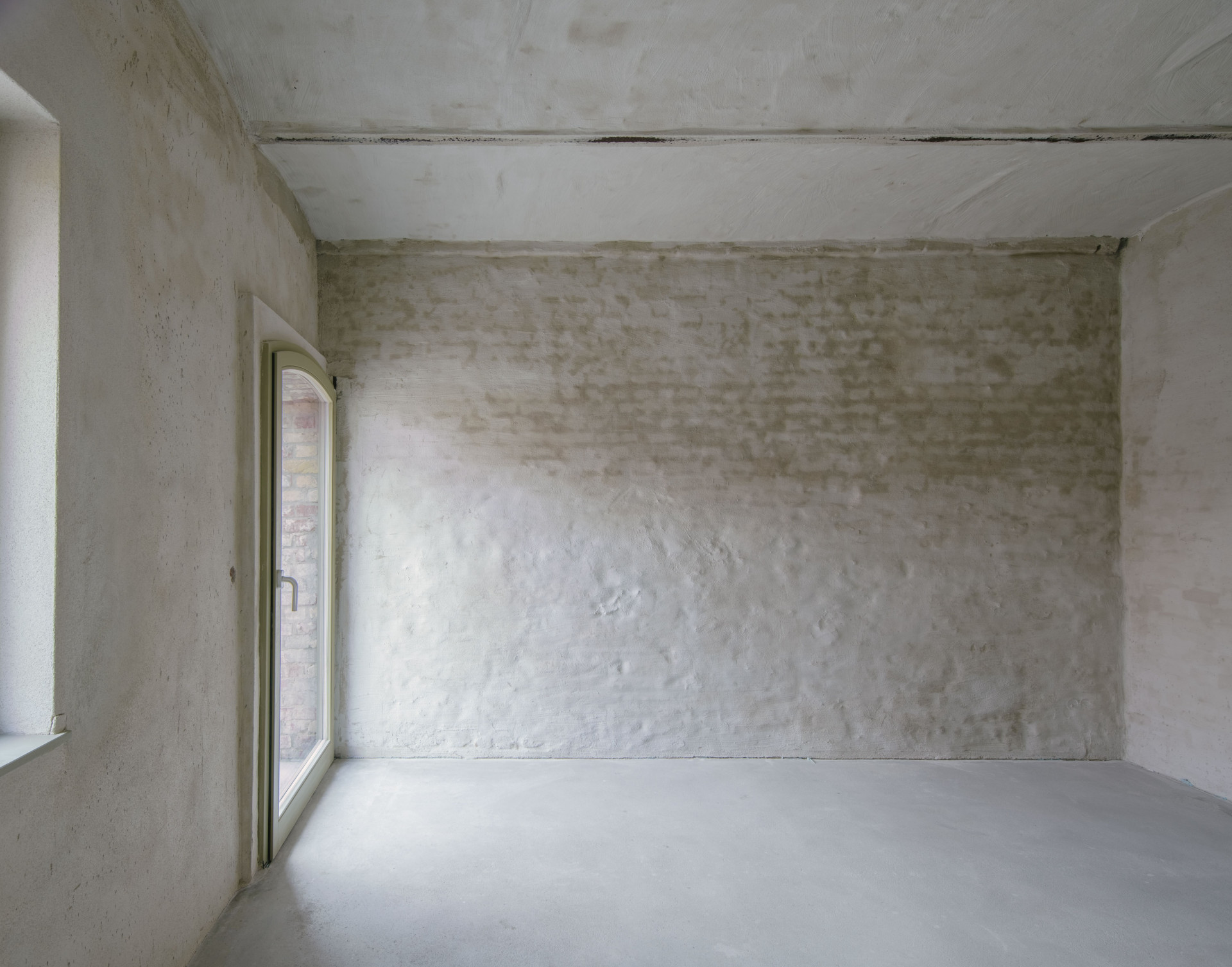 V interiérech jsou přiznané stavební materiály. V přístavbě jsou to broušené cihly a v bývalém hospodářství tradiční cihly. (Rodinný dům s ateliérem, Helga Blocksdorf Architektur)