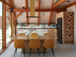 V hlavním obytném prostoru je kuchyně, jídelní stůl a sedací kout. Vše využívá stejnou paletu materiálů a barev. (Tak design, byt pod Ještědem)