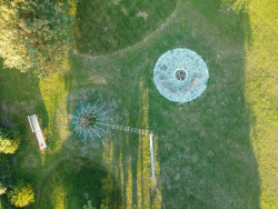 Kamenné ohniště s posezením v zeleném cípu (Příšovická náves, atakarchitekti)