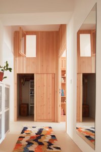 Kumbál na věci a nad ním okénko z dětského pokoje. (Plus One Architects, byt ve Vršovicích)