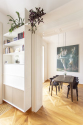 Do kuchyně se prochází portálem s původními dřevěnými kazetami, kterými se architekti inspirovali i pro nový nábytek. (Byt na nábřeží, DDAANN)