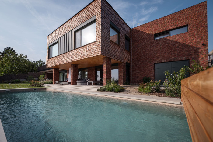 Obytný suterén plynule navazuje na zahradu s bazénem. (Elegantní rezidence v Brně podle arch. návrhu Noa architekti, generální dodavatel stavby: VESPER HOMES)