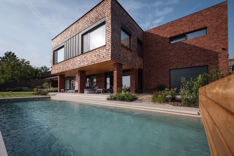 Obytný suterén plynule navazuje na zahradu s bazénem. (Elegantní rezidence v Brně podle arch. návrhu Noa architekti, generální dodavatel stavby: VESPER HOMES)