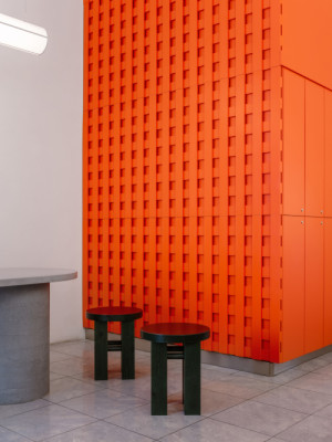 Oranžová perforovaná stěna sjednocuje interiér a podtrhuje jeho výraznou vizuální identitu. (The Kimchi; SOA architekti)