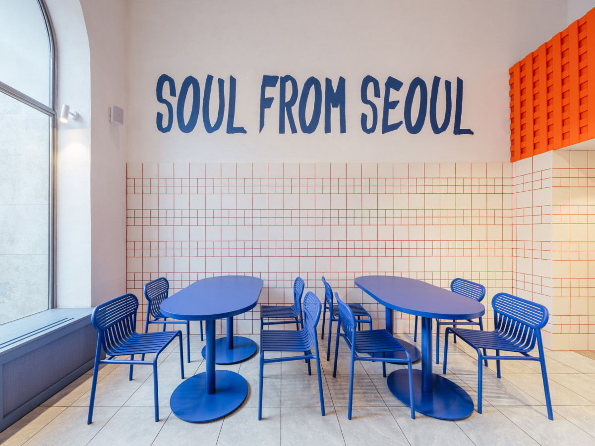 Dominantní modrá sjednocuje stoly, lavici, obklady i detaily osvětlení. (The Kimchi; SOA architekti)