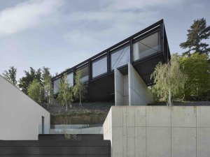 Rodinný dům vynášejí železobetonové pilíře, na nichž leží v podstatě mostní konstrukce. (Vila Sidonius ve Středočeském kraji, Stempel & Tesar architekti)