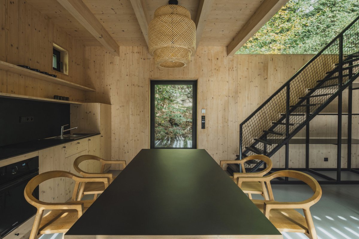 Černá se v interiéru opakuje. (Chata u Sázavy mezi skálou a řekou; Mimosa Architekti)
