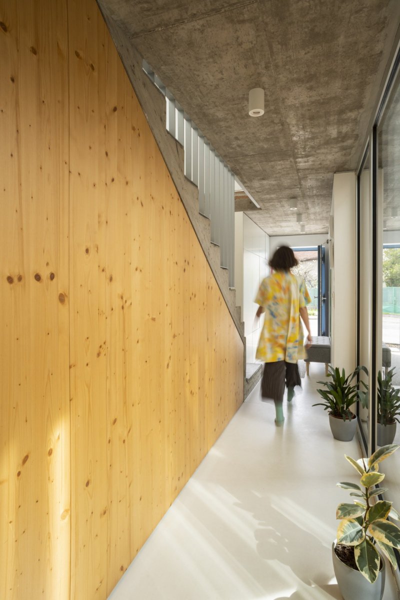 Pod schodištěm vznikl úložný prostor, který je zakrytý masivní smrkovou biodeskou. (Úzký patrový dům v Žilině, architektonické studio treea - architekt Peter Kasman.)