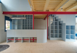 Interiér obchodu s cyklistickými koly člení materiály a barevné akcenty.