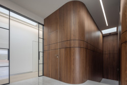 Průhled interiérem do chodby, která je obložená ořechovým dřevem s neopakovatelnou kresbou.