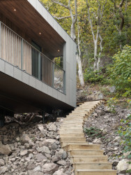 Dům na pobřeží Švédska splývá s okolní vegetací. Je za tím i fasáda z šedivého vláknocementu Swisspearl. 