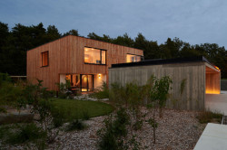 Dům je opláštěn dřevěným obkladem. Ten brzy zešedne, zeleň na zahradě vyroste a celý dům tak více splyne s okolím. (Dům ve třech zahradách, Air ateliér)