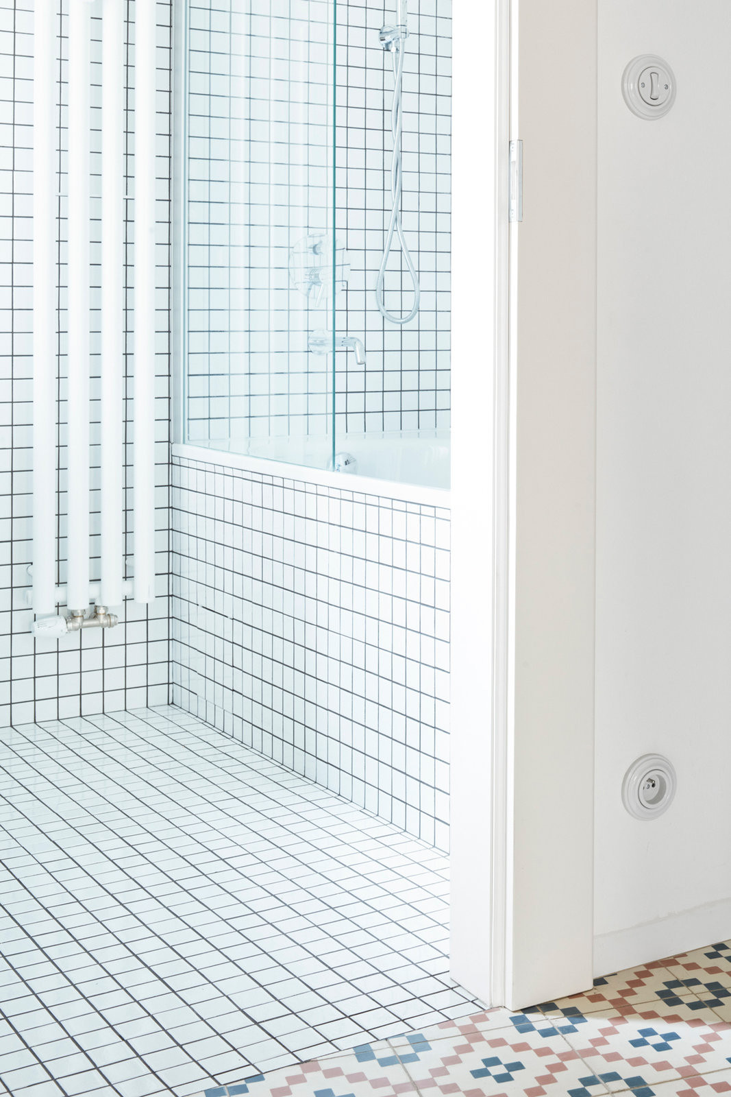 Do malé koupelny architekti zvolili bílý mozaikový obklad, který prostor opticky zvětšuje. (Rekonstrukce bytu na Letné; 0,5 Studio)