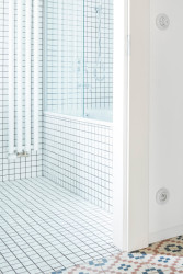 Do malé koupelny architekti zvolili bílý mozaikový obklad, který prostor opticky zvětšuje. (Rekonstrukce bytu na Letné; 0,5 Studio)