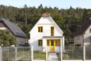 Do údolí na Praze-Západ zapadá, okolo má zahradu s rozmanitou zelení a plot, který není hradbou. (Rekonstrukce prvorepublikového domu v údolí, 0,5 Studio)