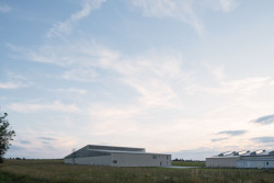 Ze severní strany stavbu částečně schovává násyp s pozvolným sklonem. (Hangár ve Zbraslavicích, Studio Raketoplán)