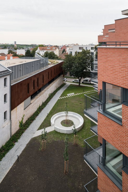 Pohled do parku a na sousední budovu bývalého pivovaru s přístavbou (Rezidence Starý pivovar v Brně-Králově Poli, Atelier RAW)
