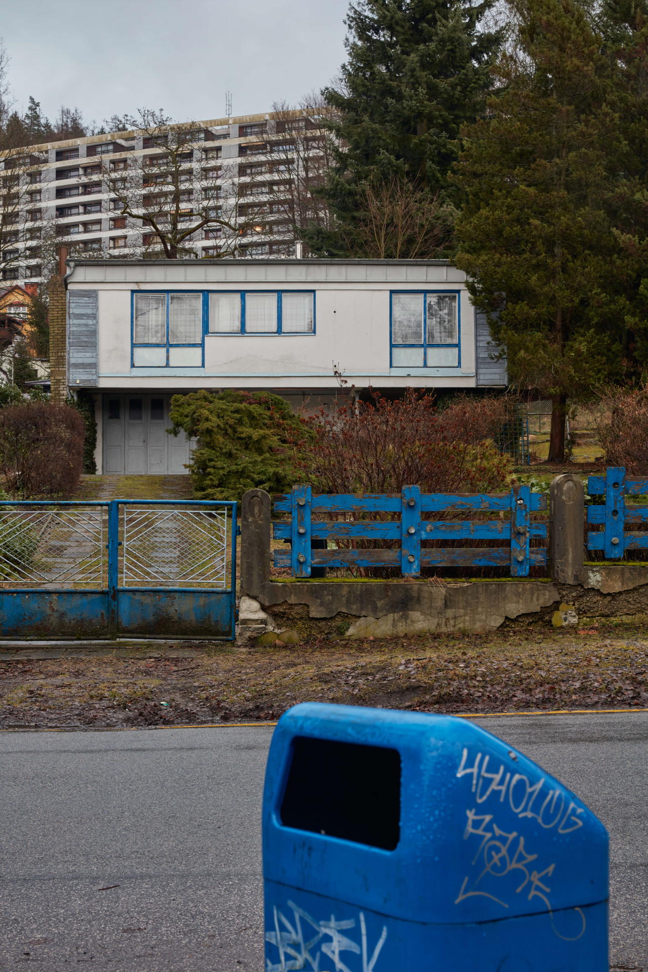 Má modrá okna a stejně modrý plot, ten je taky autorský, navrhl ho Karel Hubáček.