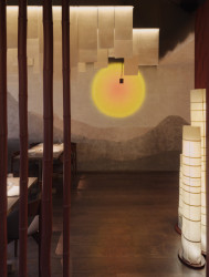 Kruhový akcent připomínající zapadající slunce nad abstraktní krajinou (Yami Sushi House; annaMAT)