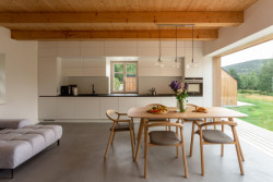 Hlavní obytná místnost s kuchyní se ven obrací celou prosklenou stěnou. (Chata Lipka na Šumavě, Harazim Karel Architektura)