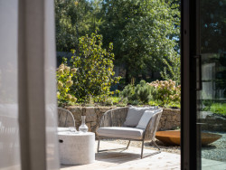 Přímo z obývacího pokoje můžete skrze okno vyjít na terasu na zahradě.