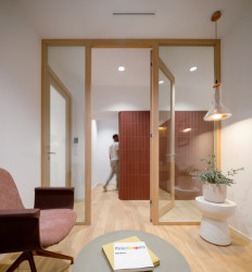 Prosklené příčky mezi místnostmi zajišťují akustický komfort a současně prostory vizuálně propojují. (Zrekonstruované kanceláře v Paláci Akropolis; Marco Maio Architects)