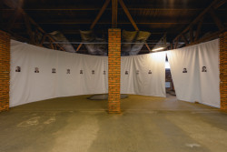 Expozice v Rudé věži smrti, studio COSMO: první část - uvěznění. Člověk se tu ocitne obklopen tvářemi vězňů a netuší, co bude dál.