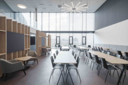 Prosvětlená kantýna, která se flexibilitou nábytku může proměnit v sál uzpůsobený seminářům či jiným akcím.