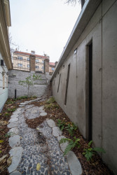 Podél kaple se vine symbolické koryto, které za deště naplňuje voda stékající ze střechy. (Kaple v Praze-Záběhlicích; JIRSA – ARCHITEKTI)