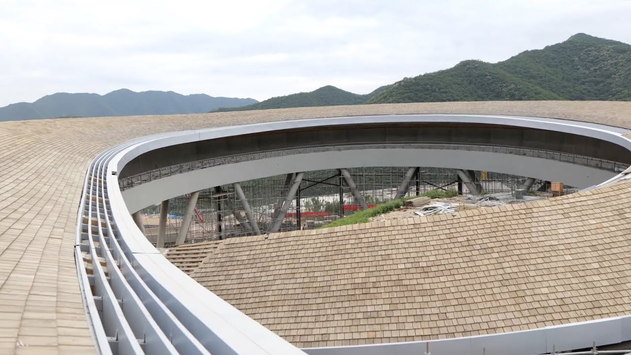 Konstrukci o délce bezmála dvou kilometrů, jejíž střechu pokrývají dřevěné šindele, navrhl ateliér významného čínského architekta Li Xingganga v rámci platformy China Architecture Design & Research Group, která stojí za návrhem olympijské vesnice a dalších nových sportovních areálů.