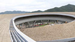 Konstrukci o délce bezmála dvou kilometrů, jejíž střechu pokrývají dřevěné šindele, navrhl ateliér významného čínského architekta Li Xingganga v rámci platformy China Architecture Design & Research Group, která stojí za návrhem olympijské vesnice a dalších nových sportovních areálů.