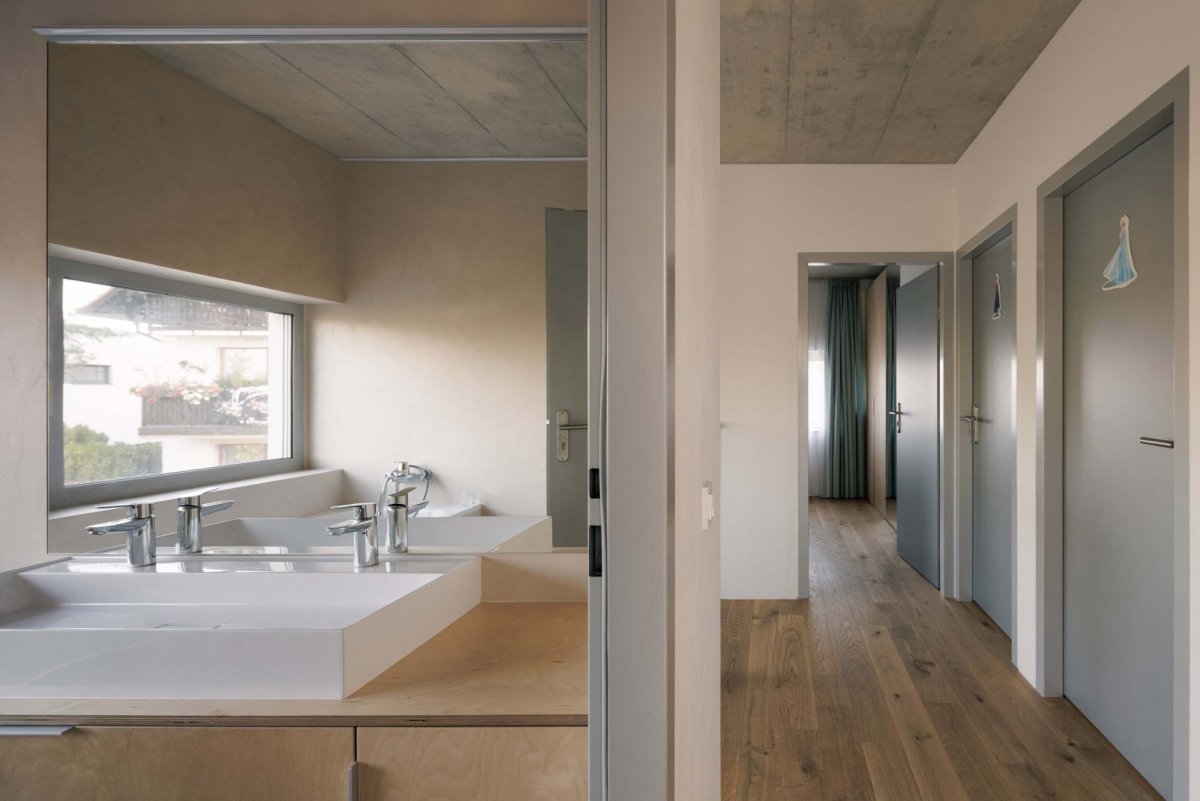 Chodba s koupelnou v druhém patře. (Rodinný dům v Radotíně, Papundekl architekti)
