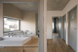 Chodba s koupelnou v druhém patře. (Rodinný dům v Radotíně, Papundekl architekti)