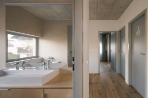 Chodba s koupelnou v druhém patře. (Rodinný dům v Radotíně, Papundekl architekti)