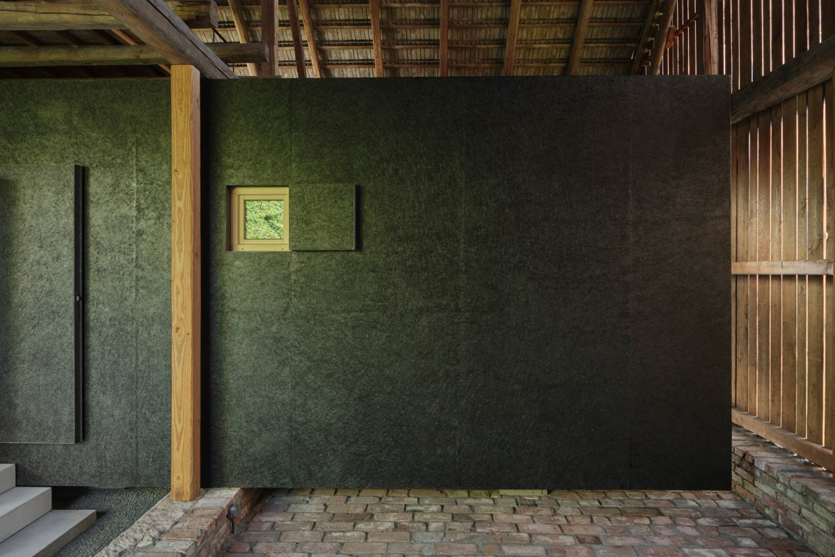 Obálku boxu tvoří OSB desky, natřené černým asfaltovým nátěrem. (Krabice ve stodole; Facha architekti)