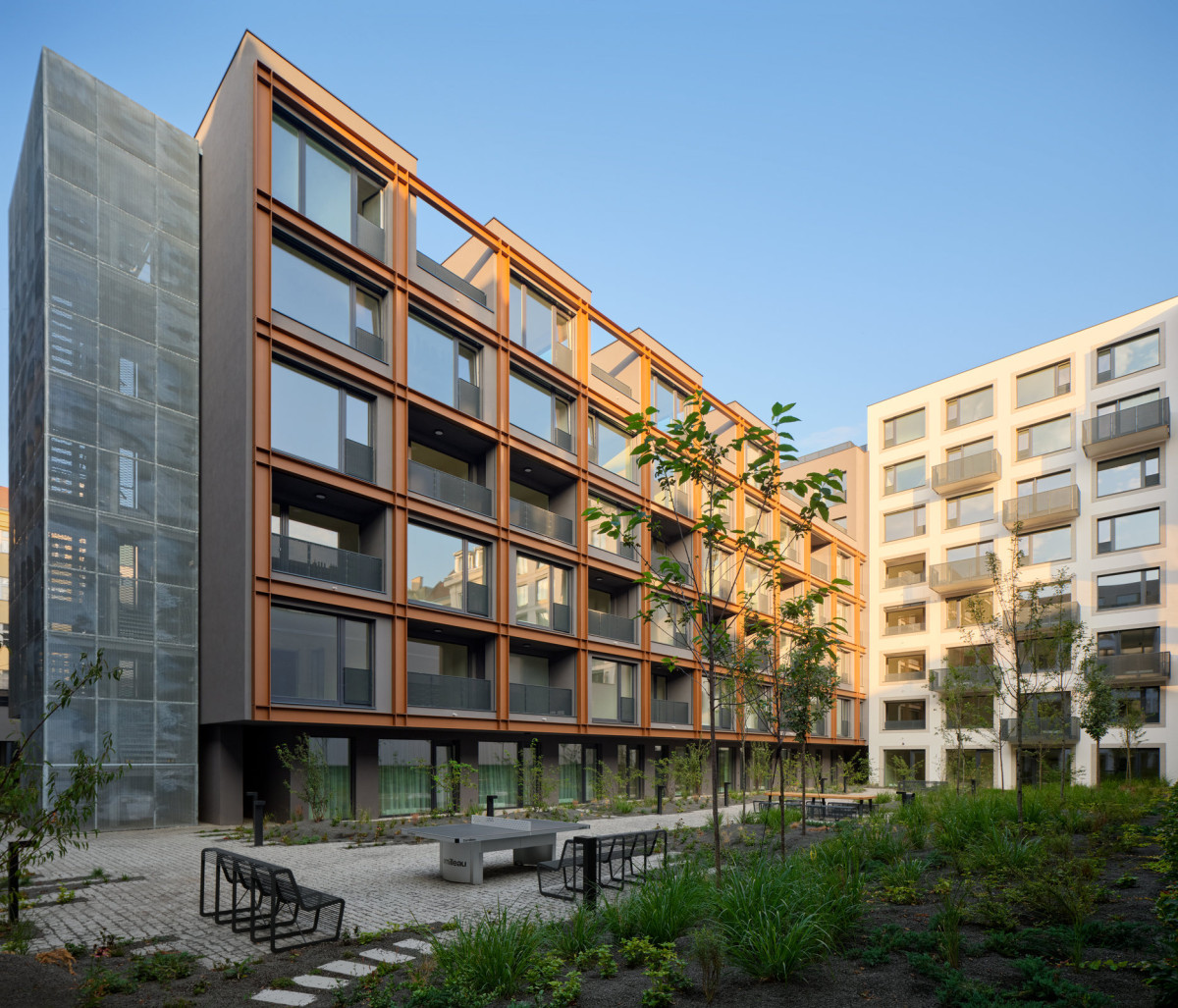 Za městskou fasádou se otevírá klidný zelený vnitroblok, který kontrastuje s industriálním výrazem domu. (MiDO Harfa; QARTA Architektura)