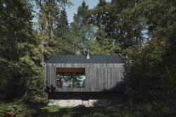 Fasáda z opálených modřínových prken (Chata u Sázavy mezi skálou a řekou; Mimosa Architekti)