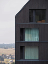 Velkorysá okna nabízí výhled do krušnohorské zvlněné krajiny. (Bytový dům Krušec, monom)